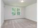 Inviting bedroom bathed in natural light from a window showcasing trees outside at 7108 Hambright Rd, Huntersville, NC 28078