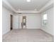 Large primary bedroom with neutral carpet, natural light, tray ceilings and ensuite bathroom at 7108 Hambright Rd, Huntersville, NC 28078