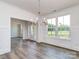 Dining room featuring hardwood floors, wainscoting, modern chandelier and large windows, creating an elegant space at 7108 Hambright Rd, Huntersville, NC 28078