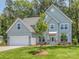 Charming two-story home with a light blue exterior, well-manicured lawn, and an attached two-car garage at 7108 Hambright Rd, Huntersville, NC 28078