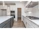 Well-appointed kitchen with a gray island, white cabinets, quartz counters, and stainless steel appliances at 7108 Hambright Rd, Huntersville, NC 28078
