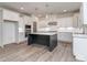 Bright, modern kitchen with white cabinetry, a dark island, stainless steel appliances, and wood-look floors at 7108 Hambright Rd, Huntersville, NC 28078