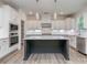 Modern kitchen features white cabinets, stainless appliances, dark island, and stylish pendant lighting at 7108 Hambright Rd, Huntersville, NC 28078