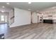 Open-concept living area with hardwood floors, stairs, and modern kitchen with a dark kitchen island at 7108 Hambright Rd, Huntersville, NC 28078