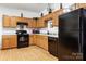 Well-lit kitchen showcasing wood cabinets and modern black appliances at 7138 Somerset Springs Dr, Charlotte, NC 28262