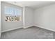 Bright bedroom with neutral carpeting and a window overlooking the neighborhood at 720 Flare Dr, Tega Cay, SC 29708
