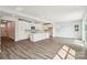 Open-concept floor plan showcasing kitchen, stainless appliances, and spacious living room with recessed lighting and hardwood floors at 720 Flare Dr, Tega Cay, SC 29708