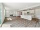 Spacious open-concept living area showcasing a fireplace, recessed lights, and hardwood floors flowing into the modern kitchen at 720 Flare Dr, Tega Cay, SC 29708