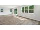 Bright open-concept living room features hardwood floors, large windows, and sliding glass doors to outdoor living space at 720 Flare Dr, Tega Cay, SC 29708