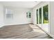 Bright open-concept living room features hardwood floors, large windows, and sliding glass doors to outdoor living space at 720 Flare Dr, Tega Cay, SC 29708