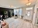 Modern living room featuring light gray floors, decor shelves, and plenty of natural light at 9419 Silverdale Ln, Charlotte, NC 28269