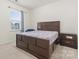 Bedroom with carpet, window, and a large bed frame and matching nightstand at 966 Nw Parkland Pl, Concord, NC 28027