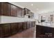 Stylish kitchen with dark wood cabinets, granite countertops, and a subway tile backsplash at 966 Nw Parkland Pl, Concord, NC 28027