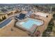 Aerial view of a sparkling community pool, playground, volleyball court, and picnic pavilion for endless outdoor fun at 966 Nw Parkland Pl, Concord, NC 28027