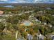 A panoramic aerial shot showcasing community pool, picturesque neighborhood, lush trees, and serene lake at 1005 Willow Bank Ln, Belmont, NC 28012