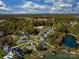 Stunning aerial view showcasing the community, mature trees, serene lake, and sparkling pool at 1005 Willow Bank Ln, Belmont, NC 28012