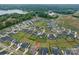 Aerial view of a community featuring single-Gathering homes and green spaces near a lake at 1005 Willow Bank Ln, Belmont, NC 28012