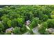 Overhead view of a brick home nestled among tall trees in a quiet suburban neighborhood at 10501 Olde Irongate Ln, Mint Hill, NC 28227