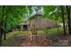 Backyard view of a brick home featuring a fenced yard, deck, and access stairs at 10501 Olde Irongate Ln, Mint Hill, NC 28227