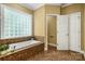 Bright bathroom featuring a tiled bathtub and shower combination at 10501 Olde Irongate Ln, Mint Hill, NC 28227