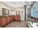 A modern bathroom with a double sink vanity, glass-enclosed shower, and bathtub at 10501 Olde Irongate Ln, Mint Hill, NC 28227
