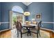 Dining room featuring blue walls, wood table, and large arched window at 10501 Olde Irongate Ln, Mint Hill, NC 28227
