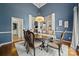 Formal dining room with blue accent wall and large wood table at 10501 Olde Irongate Ln, Mint Hill, NC 28227