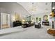 Vaulted ceiling living room with plush carpet, piano, fireplace, and natural light flowing through the windows at 10501 Olde Irongate Ln, Mint Hill, NC 28227