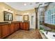Elegantly appointed main bathroom with dual sinks, a glass-enclosed shower, and a soaking tub for relaxation at 10501 Olde Irongate Ln, Mint Hill, NC 28227