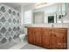 Bathroom with a wooden vanity, large mirror, and shower with patterned curtain at 107 Golden Valley Dr, Mooresville, NC 28115
