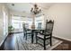 Open dining area with elegant chandelier, dark hardwood floors, bright white walls and plenty of sunlight at 107 Golden Valley Dr, Mooresville, NC 28115