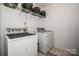 Functional laundry area equipped with a washer, dryer, and storage shelves for efficient chores at 107 Golden Valley Dr, Mooresville, NC 28115