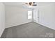 Spacious bedroom featuring neutral carpet, natural light from window, and a white door at 108 Greenway View Ct, Mount Holly, NC 28120