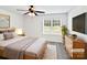 Comfortable bedroom with a queen-sized bed, neutral decor, and a window overlooking greenery at 108 Greenway View Ct, Mount Holly, NC 28120