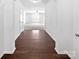 Inviting hallway with dark hardwood floors leading to a spacious living area with gray carpet at 108 Greenway View Ct, Mount Holly, NC 28120