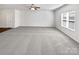 Spacious, carpeted living room with a ceiling fan and large window with blinds at 108 Greenway View Ct, Mount Holly, NC 28120