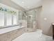 Luxurious bathroom featuring a soaking tub and a glass-enclosed shower at 12029 Forest Home Dr, Fort Mill, SC 29708