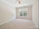 Spacious bedroom with plush carpeting, a ceiling fan, and a large window at 12029 Forest Home Dr, Fort Mill, SC 29708
