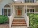 Inviting front porch with brick steps, ceiling fans and a stained wood front door at 12029 Forest Home Dr, Fort Mill, SC 29708