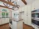 Spacious kitchen featuring white cabinets, hardwood floors, island with breakfast bar, and stainless appliances at 12029 Forest Home Dr, Fort Mill, SC 29708