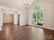Open-concept living room with hardwood floors, bright windows, chandelier and elegant trim at 12029 Forest Home Dr, Fort Mill, SC 29708