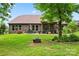 Expansive backyard showcasing a brick home, patio seating, a grill, and vibrant landscaping at 137 Leaning Tower Dr, Mooresville, NC 28117