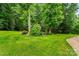 Beautiful backyard with vibrant greenery, mature trees, and a charming path leading to a tranquil retreat at 137 Leaning Tower Dr, Mooresville, NC 28117