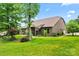 Lush backyard featuring mature trees, a brick home, and a well-manicured lawn, creating a serene outdoor space at 137 Leaning Tower Dr, Mooresville, NC 28117
