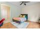 Bright bedroom featuring a ceiling fan, striped bedding, and a cozy rug over wood floors at 137 Leaning Tower Dr, Mooresville, NC 28117