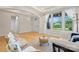 Cozy living room featuring hardwood floors, tray ceilings, and ample natural light from large windows at 137 Leaning Tower Dr, Mooresville, NC 28117
