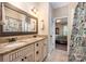 Bathroom with double vanity featuring granite countertop, decorative mirror, tile floors, and shower with decorative curtain at 145 Waterwood Dr, Shelby, NC 28150
