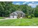 Charming home with stone accents, manicured lawn, and two-car garage nestled among mature trees at 145 Waterwood Dr, Shelby, NC 28150