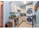 Laundry room features stacked washer and dryer and utility sink with storage at 145 Waterwood Dr, Shelby, NC 28150