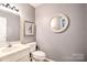 Cozy half-bathroom featuring painted walls, and a round, decorative mirror at 1633 Kiawah Ct, Gastonia, NC 28056